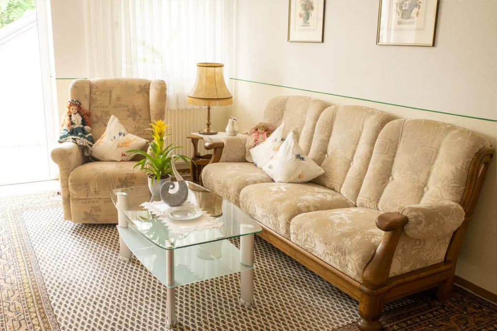 Sitzecke mit Sofa, Sessel, Stehlampe und Couchtisch am Fenster